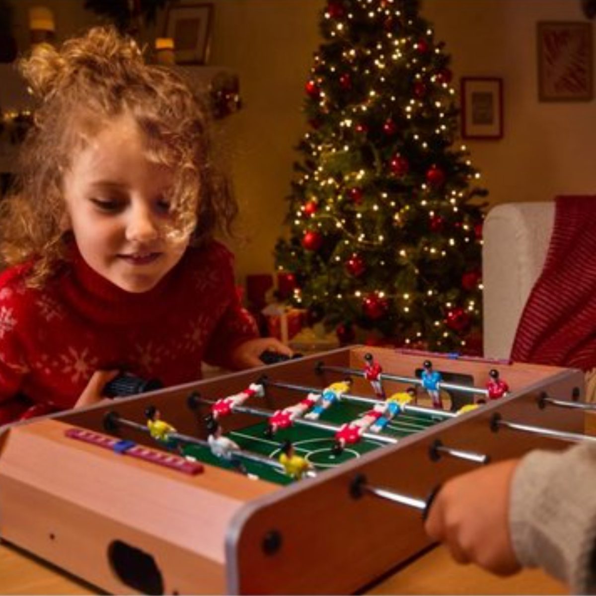 Lupilu Mini Calcio Balilla usato da una bambina in salotto con albero di Natale sullo sfondo