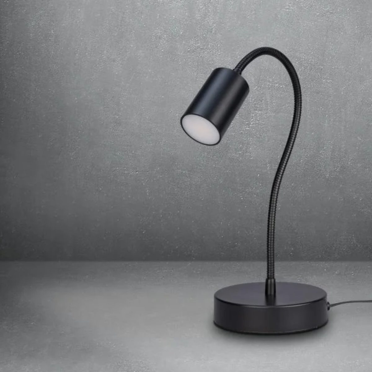 Lampada LED Livarno Home con braccio orientabile, dettaglio luce bianca calda accesa su sfondo grigio texture