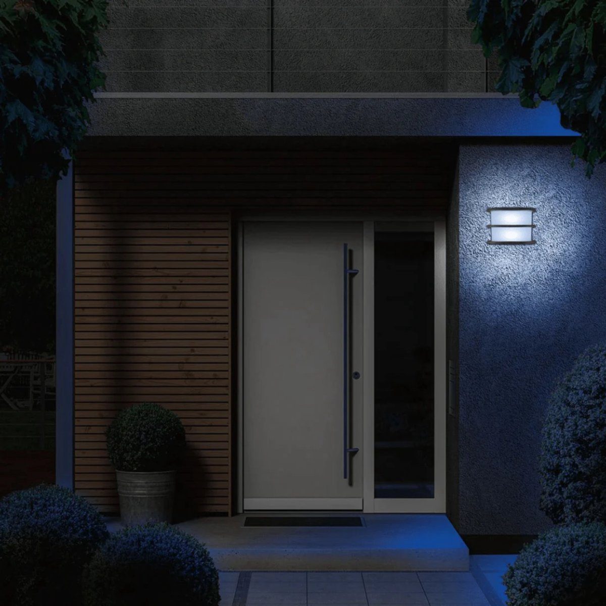 Livarno Lux applique LED esterno smart Zigbee installata su parete esterna, luce bianca accesa in ambientazione notturna
