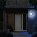 Livarno Lux applique LED esterno smart Zigbee installata su parete esterna, luce bianca accesa in ambientazione notturna