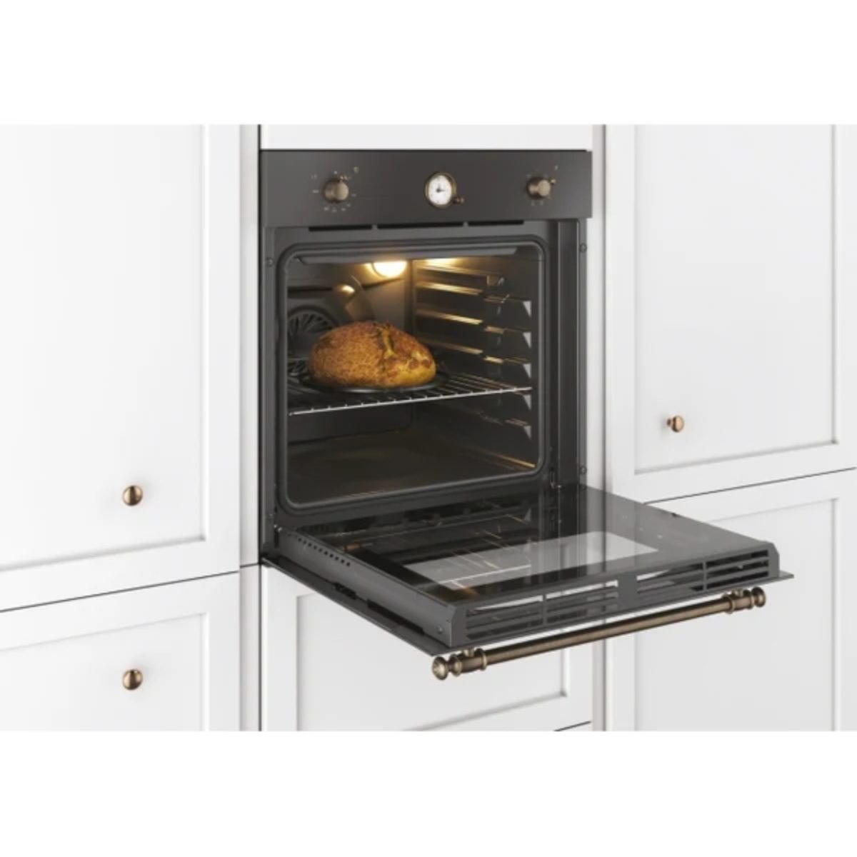 Forno da incasso Candy Classic FCC604GH/E installato in cucina bianca, sportello aperto con pane appena cotto