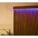 Striscia LED Livarno installata su parete in legno con effetto luce viola e rosa multicolore