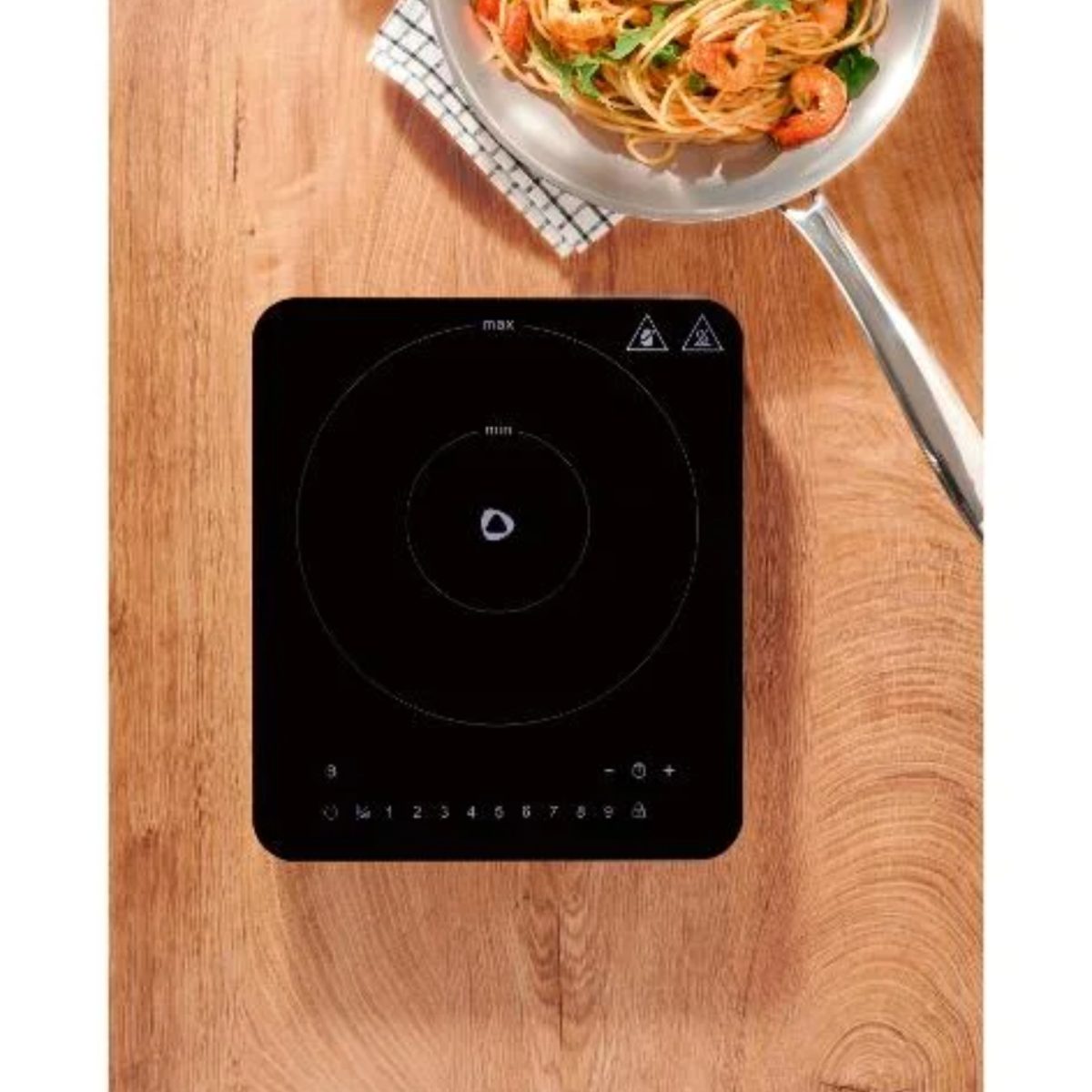 Silvercrest SIKP 2200 piastra ad induzione ricondizionata vista dall'alto su tavolo in legno con padella di pasta
