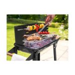 Grillmeister KANSAS in uso all'aperto durante la cottura di spiedini, salsicce e verdure sulla brace