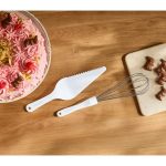 Kit frusta e spatola per dolci usati con torta rosa decorata e cioccolatini a forma di coniglietto