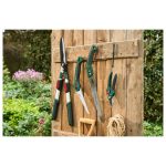 Segaccio Parkside appeso insieme a cesoie e forbici da giardino su parete in legno