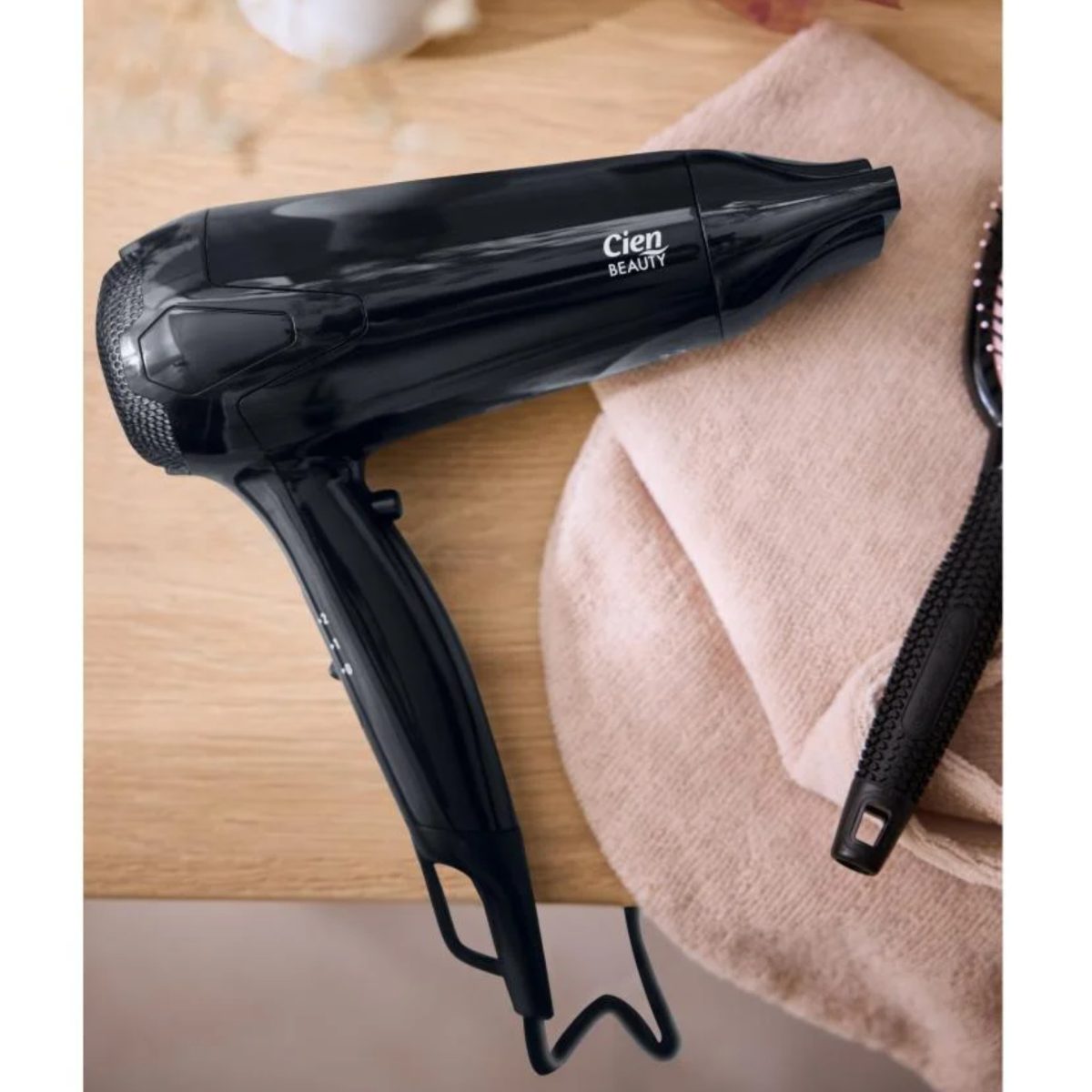 Fön Cien Beauty 2200W nero ricondizionato appoggiato su asciugamano con spazzola per capelli inclusa