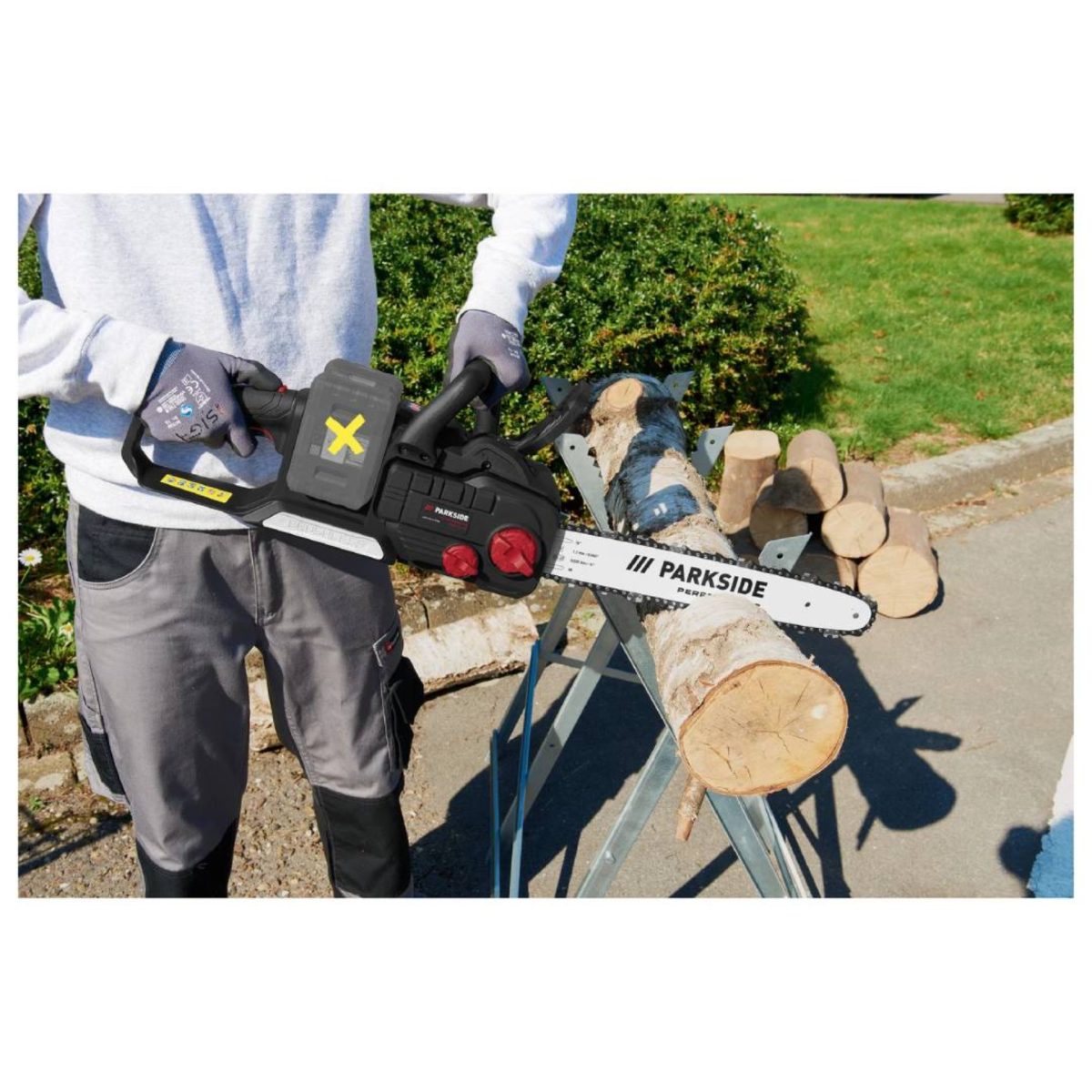 Uomo utilizza la motosega Parkside PPKSA 40 per tagliare un tronco di legno
