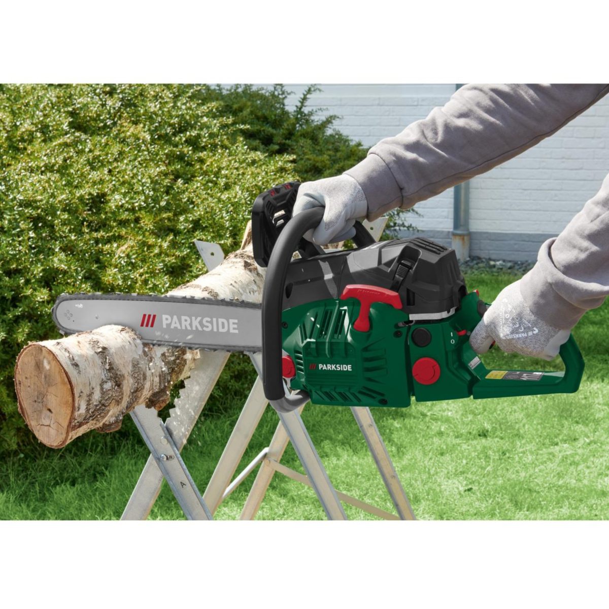 Motosega Parkside PBKS 53 in azione mentre taglia un tronco di legno su cavalletto da lavoro
