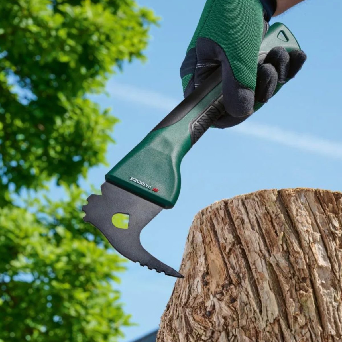 Ascia universale Parkside 19 cm in uso su un ceppo di legno, dettaglio lama seghettata e impugnatura ergonomica
