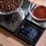 Dettaglio display Silvercrest con chicchi di caffè e caffè macinato pesati contemporaneamente sui due piatti
