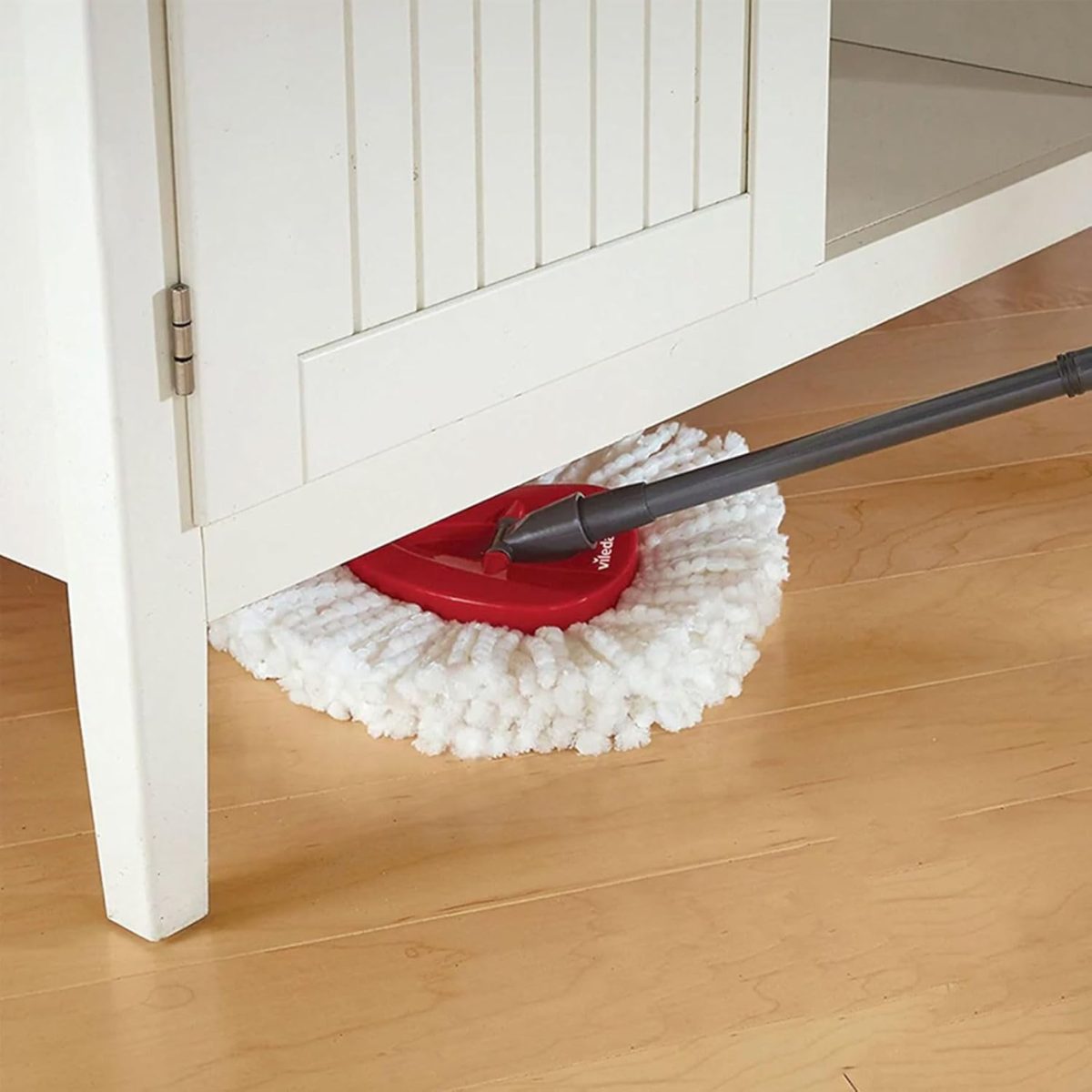 Vileda Easy Wring & Clean, dettaglio testa mocio in microfibra rossa utilizzata sotto un mobile
