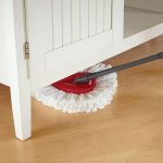 Vileda Easy Wring & Clean, dettaglio testa mocio in microfibra rossa utilizzata sotto un mobile