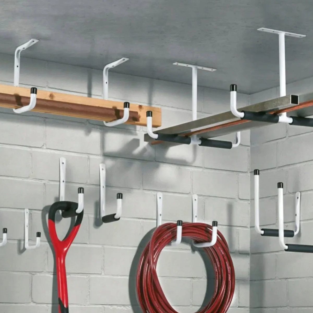 Set ganci da parete Parkside installato in garage, esempio d'uso con attrezzi e tavole appese