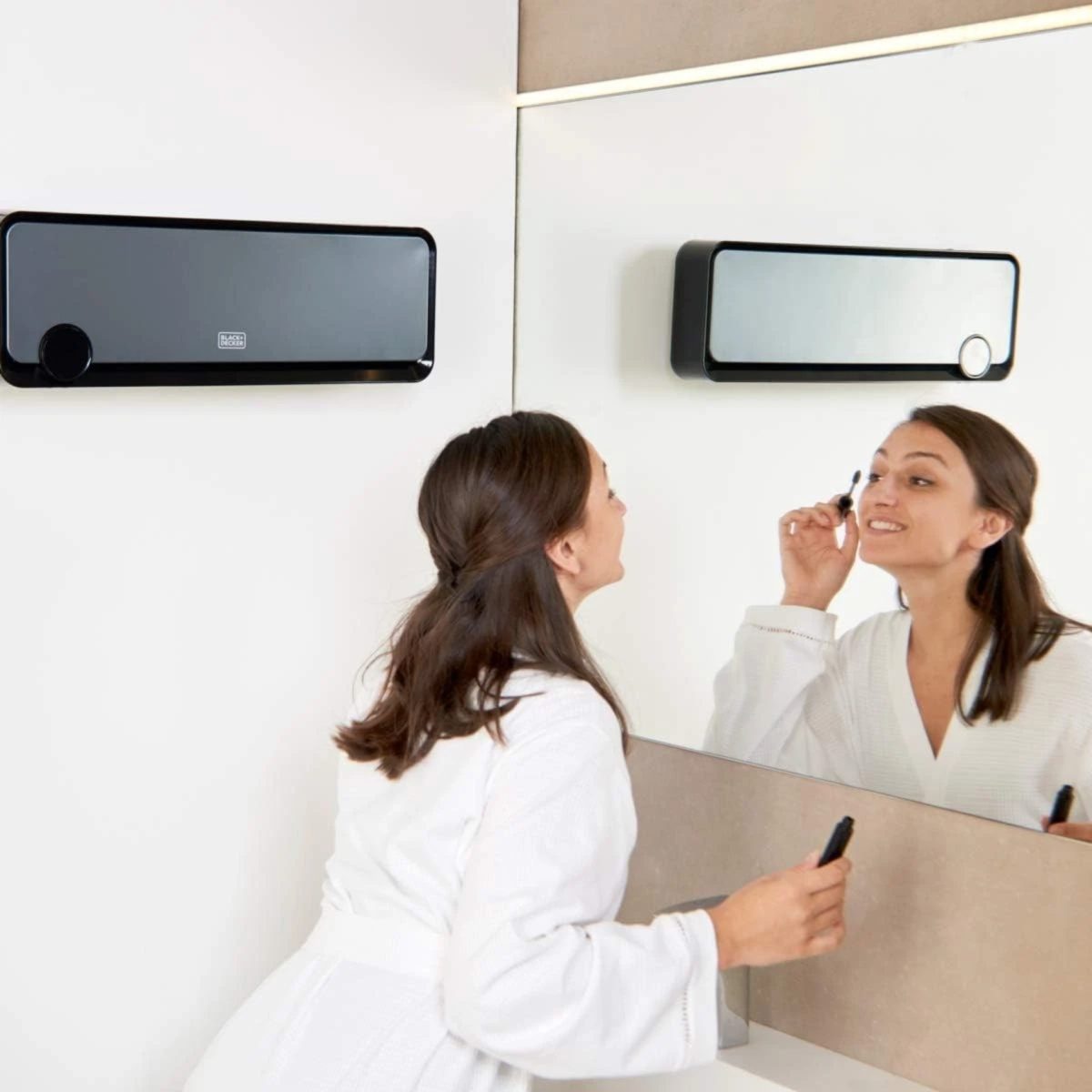 BLACK+DECKER BXWSH2000E termoconvettore installato a parete in bagno con specchio, donna si trucca