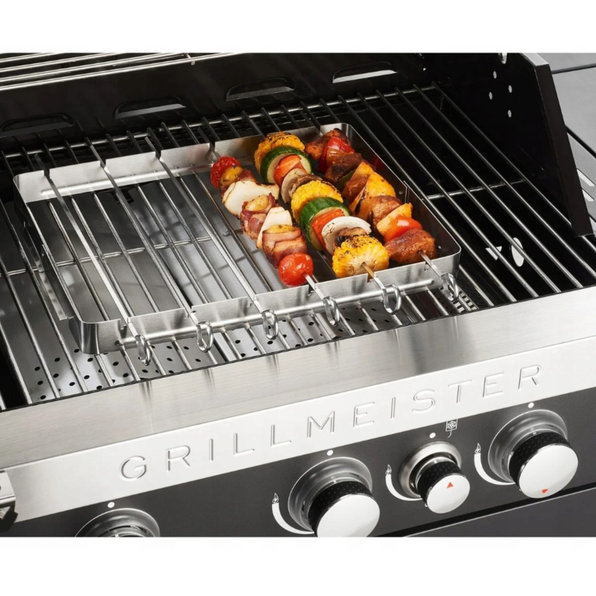 Set spiedini Grillmeister posizionato sul barbecue a gas durante la cottura di verdure e carne