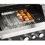 Set spiedini Grillmeister posizionato sul barbecue a gas durante la cottura di verdure e carne